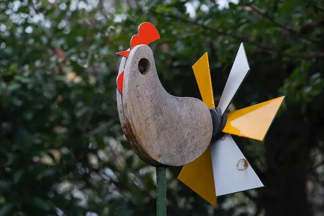 Image of a wooden windmill sculpture in the shape of a chicken.